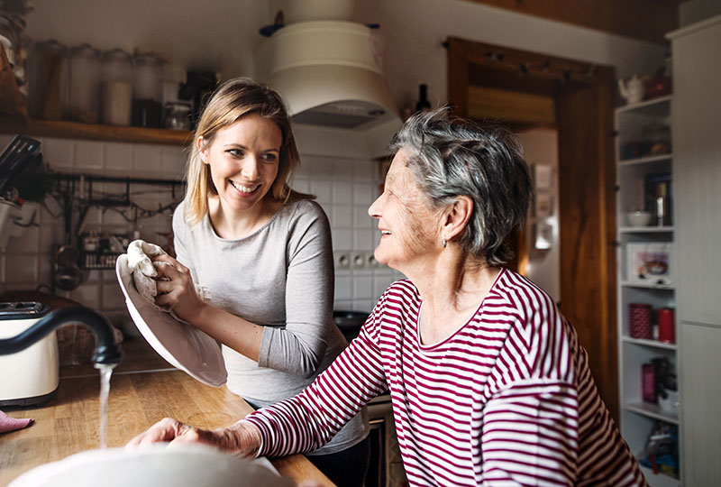 une femme qui accompagne sa m&egrave;re qui vieillit dans les taches quotidiennes